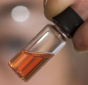 A vial of pink colored porphyrins representing the oldest intact pigments in the world.