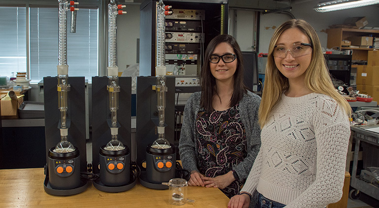 Martha Chacón-Patiño (left) and Sydney Niles in the lab with the Soxhlet extractor they use to prepare samples of asphaltenes for analysis.