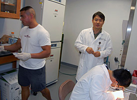 Kim (facing camera) and his postdocs perform surgery on an animal.