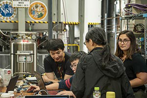 Li (far left) and other members of Cory Dean’s research group conduct an experiment on graphene.
