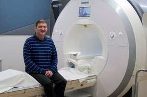 Russ Bowers pictured with one of the MRI machines at the MagLab's AMRIS Facility.