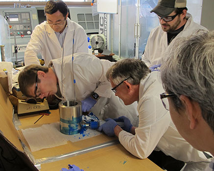 The MagLab's Ulf Trociewitz (third from left) injects epoxy into the magnet to fill the space between the windings and outer shell. Also pictured are (left to right) Xiaorong Wang of Lawrence Berkeley National Lab; Jeremy Weiss of Advanced Conductor Technologies; and Trociewitz, James Gillman and Dima Abraimov of the the National MagLab.