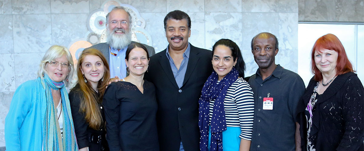 Celebrity scientist Neil deGrasse Tyson poses for a picture with MagLab and Florida State University staff and an FSU student.