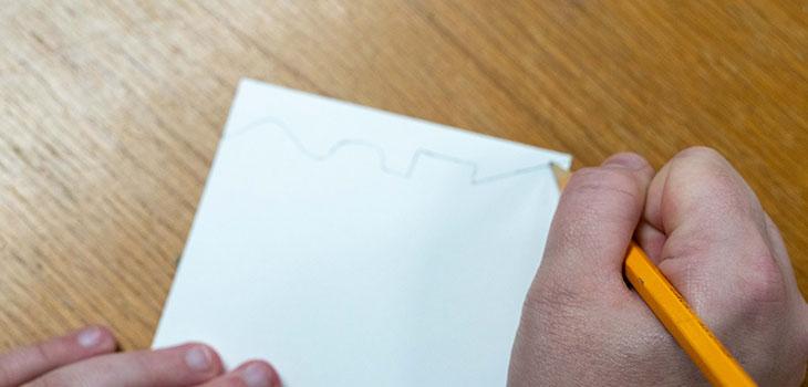 A person is drawing a squiggly, wavy, or zigzag line