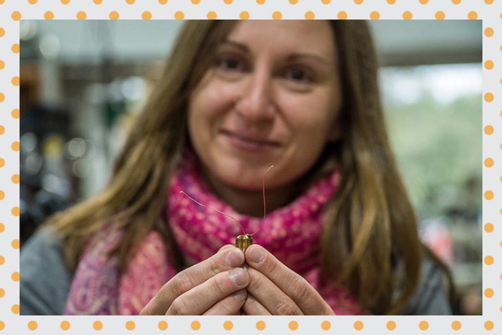 Audrey Grockowiak holds a tiny pressure cell, which compresses the sample before it enters a magnet.