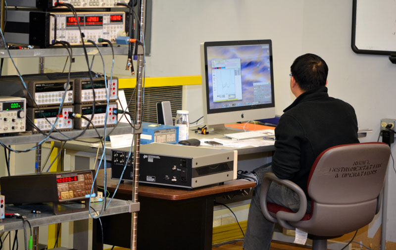 Wei Pan monitors data from his experiment in the Millikelvin Facility.