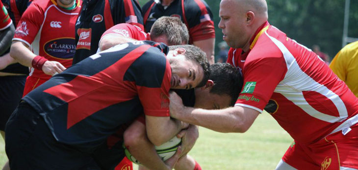 MagLab physicist Thierry DuBroca (left) tries to bring down the competition during a rugby match.