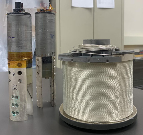 Two high-field magnet test coils (left) made of Bismuth-2212 alongside a spool of the superconducting wire.