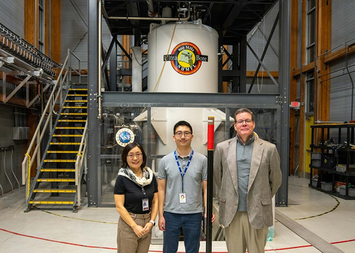 (Left to right) Professor Yan-Yan Hu, grad student Yudan Chen, and professor Sam Grant stand in front of the MagLab’s 21 tesla MRI magnet with the custom probe used for their battery dendrite research.