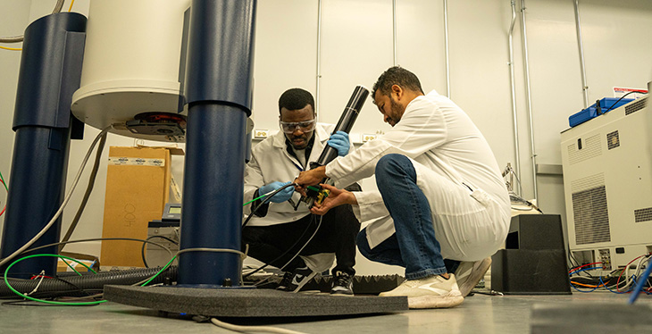 Graduate research assistant Cletus Obi and postdoctoral fellow Rokon Khan get ready to load a probe into a nuclear magnetic resonance magnet for nanodisc research at the MagLab.