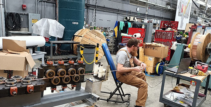 Joseph Lucia is inspecting the wire using an eddy-current machine.