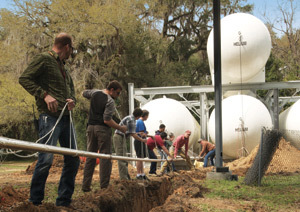 MagLab staff lay pipes for the helium-recovery project.