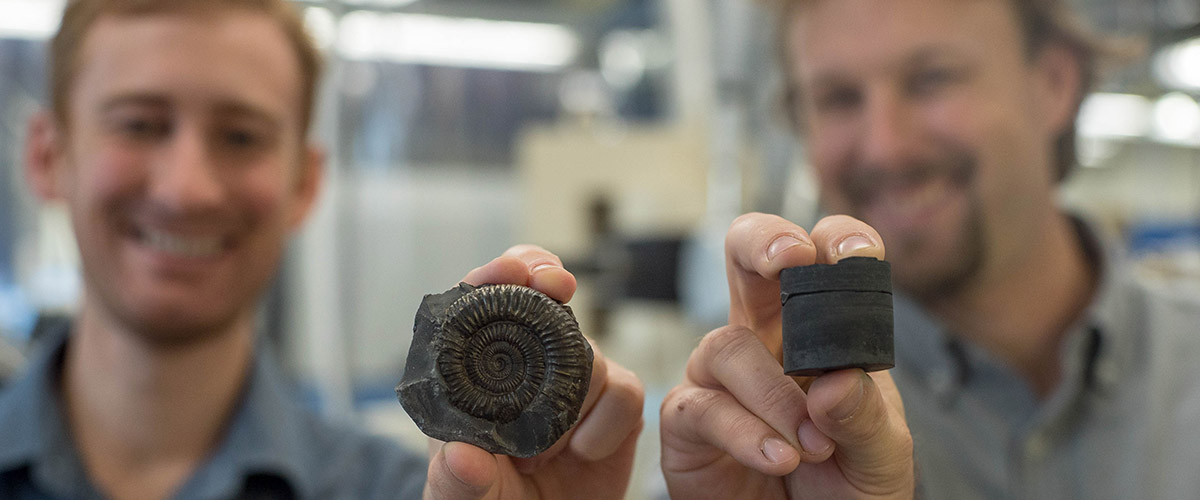 Postdoctoral Fellow Theodore Them (left, holding an extinct fossil sample) and Assistant Professor Jeremy Owens (right, holding a rock core sample). The researchers used the samples to study the global record of oxygenation.