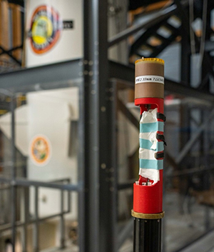 The specialized MRI coil for lithium-ion batteries  attached to a specialized probe, ready to be  placed into the main magnet for scanning.