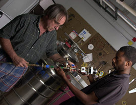 Jim Brooks (left) and Kevin Storr work on a condensed matter experiment.