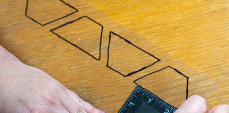 Draw a shape called a trapezoid on a plastic sheet