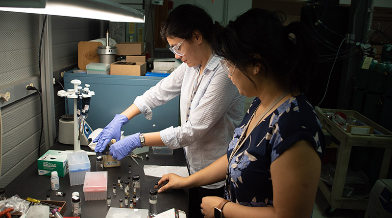 Environmental engineer Nasim Pica (left) and MagLab chemist Huan Chen prepare PFAS samples for measurement in an ICR magnet. The chemicals have been linked to immune problems, birth defects and cancer.