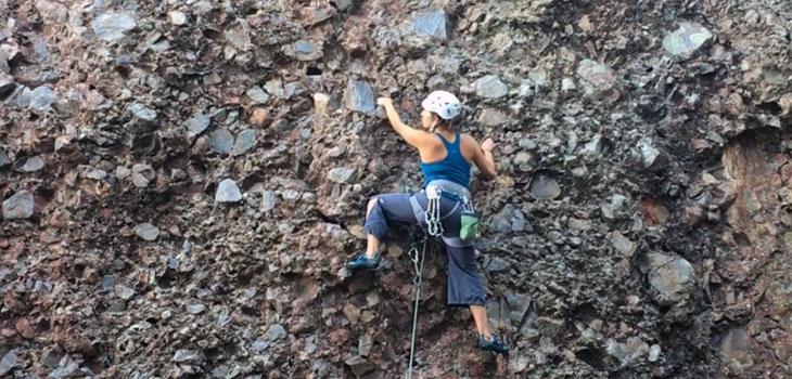 MagLab researcher Roxanne Hughes scales a rock face.