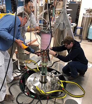 The team inserts the CORC magnet into the bore of a larger, 14-tesla magnet for testing. From left to right: Van Griffin and Youngjae Kim from the National MagLab with Jeremy Weiss of Advanced Conductor Technologies.